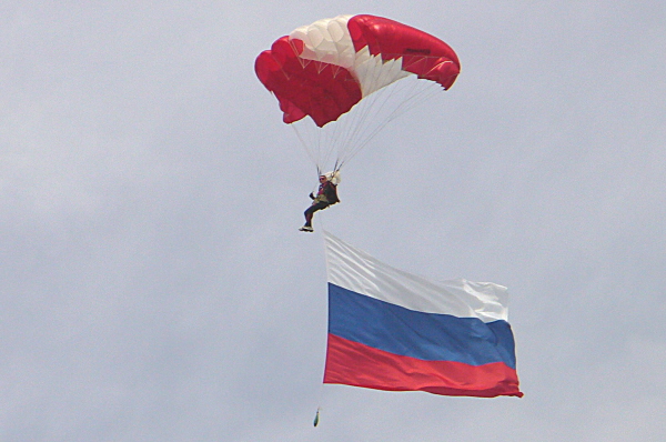 Трепещущее полотнище флага России в небе